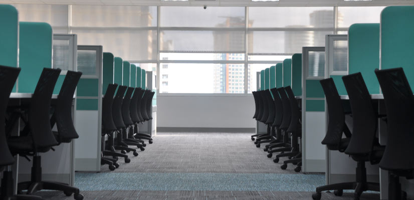 Black desk chairs with turquoise green partition screens fitted out in commercial office