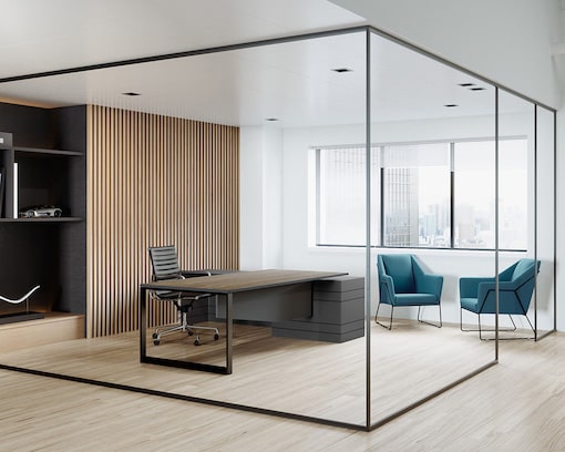 Sleek office fitted with desks and green sofa chairs
